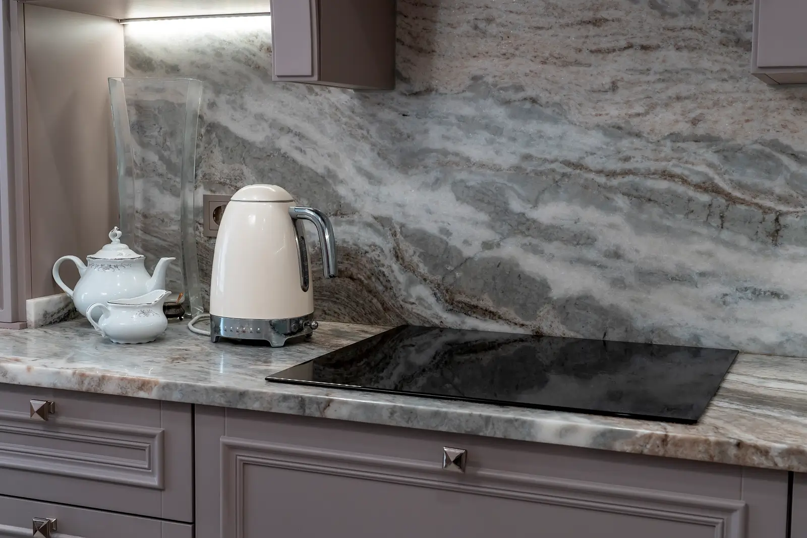Stone slab backsplash in a modern kitchen extending from countertop to cabinets