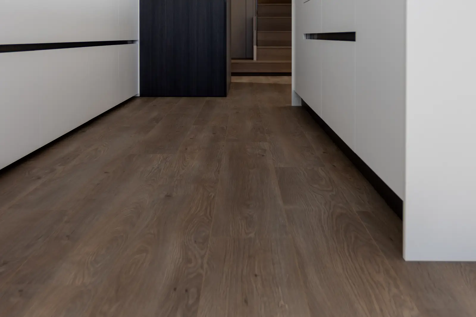 Warm oak tone vinyl plank flooring in a modern kitchen interior